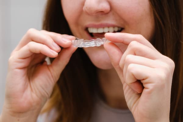 woman holding invisible aligners